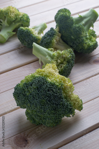 green healthy broccoli on light wood