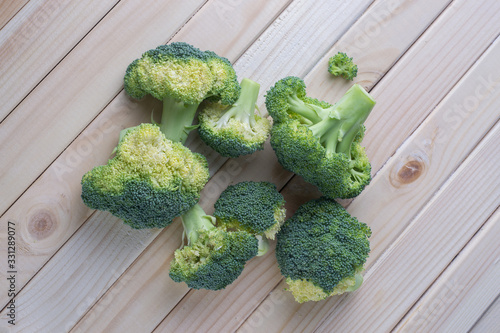 green healthy broccoli on light wood