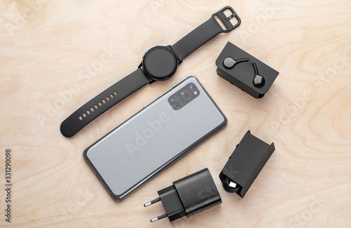 Smartphone on a wooden surface. A popular smartphone and a kit from it close-up.