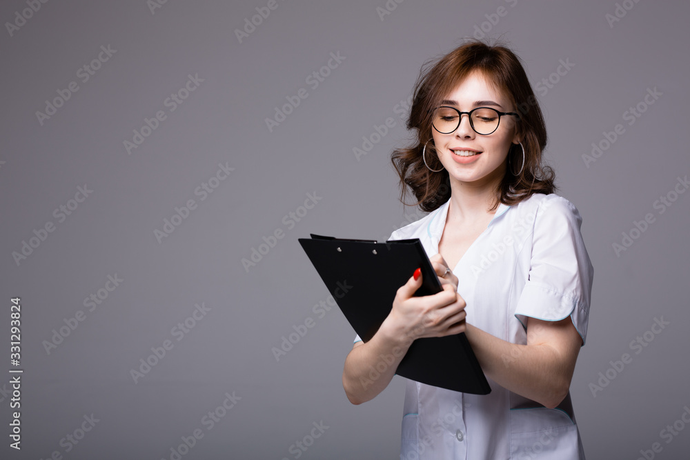 Attractive american doctor holding a black tablet with medical records of her patients Attractive american doctor holding a black tablet with medical records of her patients