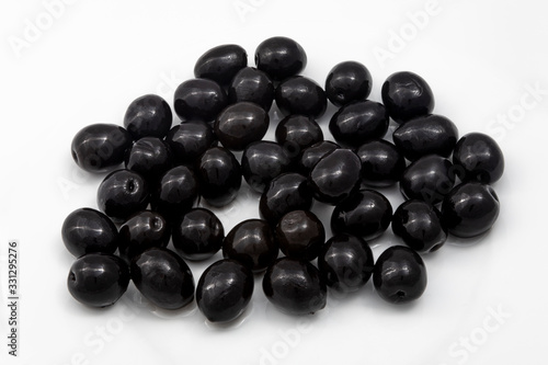 a handful of black olives on a white background © Armando