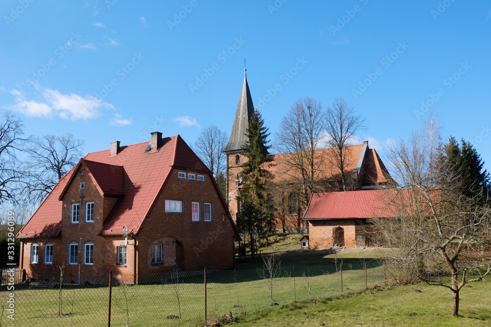 Fototapeta premium Historic brick church and presbytery in the village of Huta Kalna, Bory Tucholskie, Poland