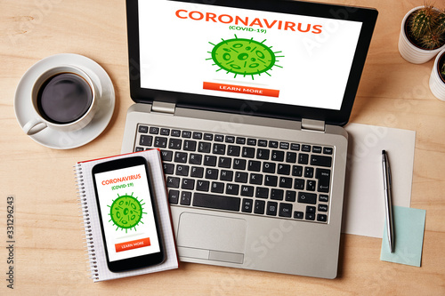 Coronavirus, covid-19 concept on laptop and smartphone screen over wooden table. Top view