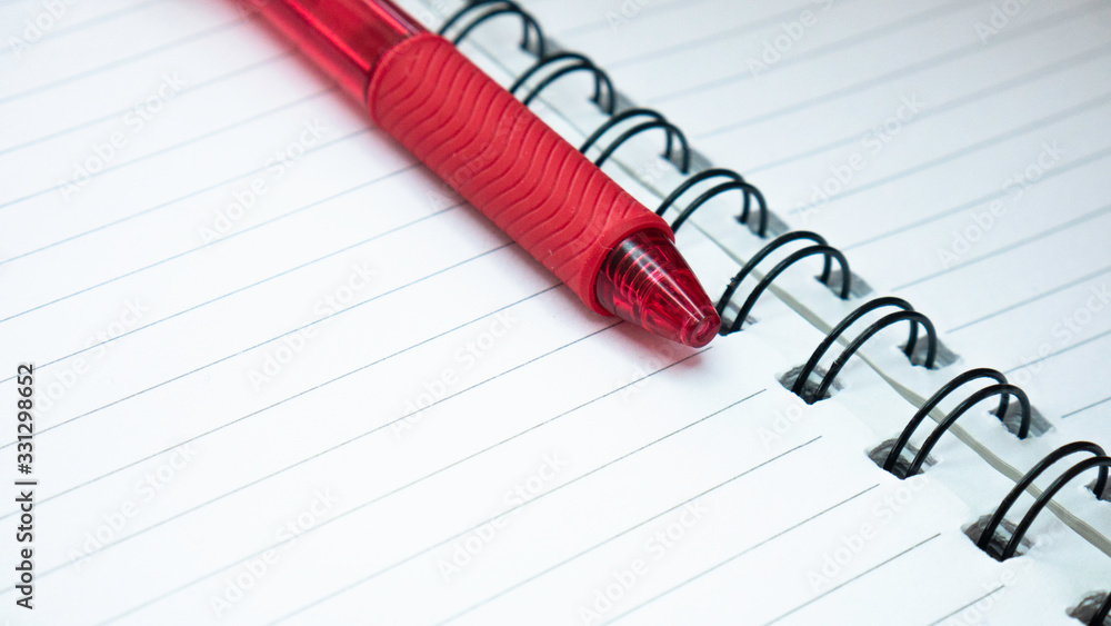 Close up of lines notebook and red pencil. Spiral notepad paper background. Close up of lines notebook and red pencil. Spiral notepad paper background.