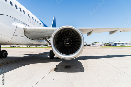 Engine and a wing of an aircraft plane at the airport. Airline, aeronautics, and travelling concept.