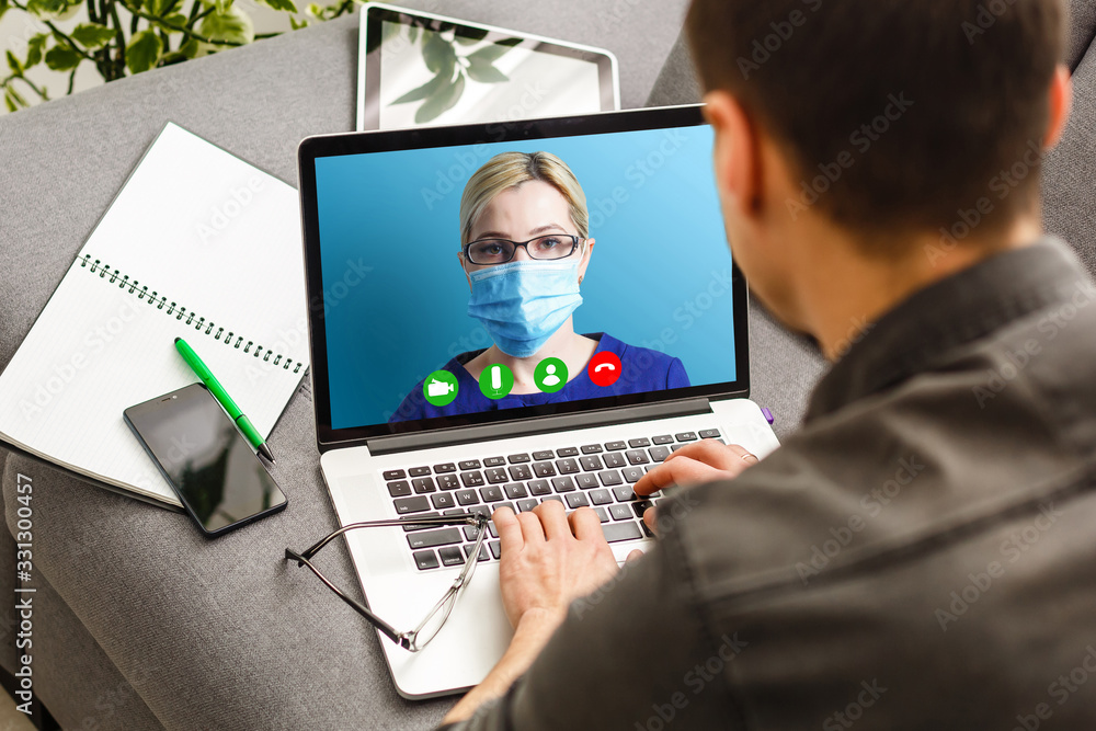 Young Female Doctor Video Chatting On Laptop In Clinic Young Female Doctor Video Chatting On Laptop In Clinic