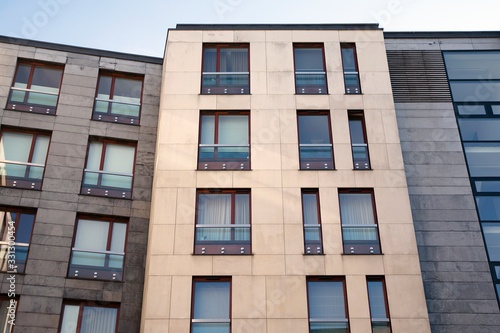 Exterior of new apartment buildings on a blue cloudy sky background. No people. Real estate business concept.