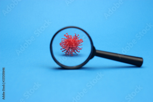 abstract model of a coronavirus in the selective focus of a magnifying glass