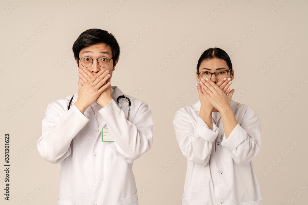 Image of asian young doctors covering their faces during viral disease Image of asian young doctors covering their faces during viral disease