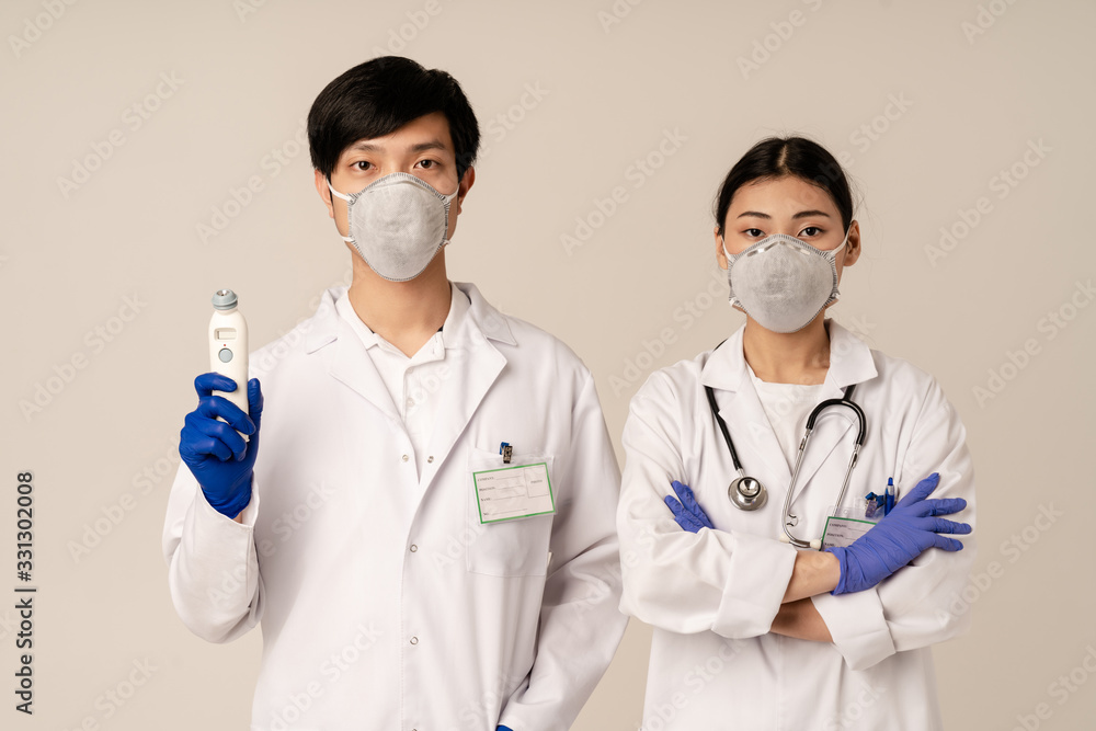 Image of asian doctors in protective masks holding medical equipment Image of asian doctors in protective masks holding medical equipment