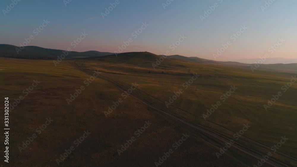 Aerial field of dry yellow grass. Steppe on Olkhon Island. Lake Baikal, Russia. Drone footage hills in the sunset Aerial field of dry yellow grass. Steppe on Olkhon Island. Lake Baikal, Russia. Drone footage hills in the sunset