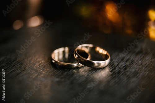 Elegant wedding rings for the bride and groom on a black background with highlights, macro, selective focus