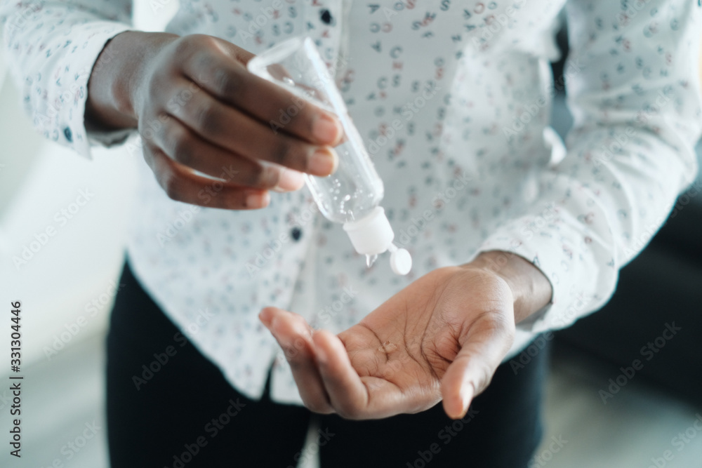 African American Woman Disinfecting Skin With Hand Sanitizer