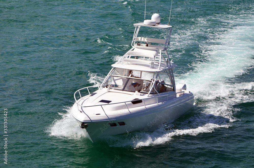 View of a high-end sport fishing boat powered by three outboard engines and equipped with a tuna tower. View of a high-end sport fishing boat powered by three outboard engines and equipped with a tuna tower.