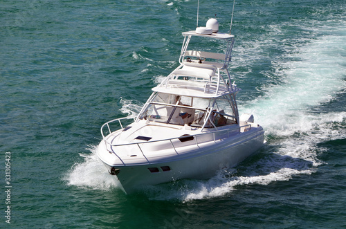View of a high-end sport fishing boat powered by three outboard engines and equipped with a tuna tower.