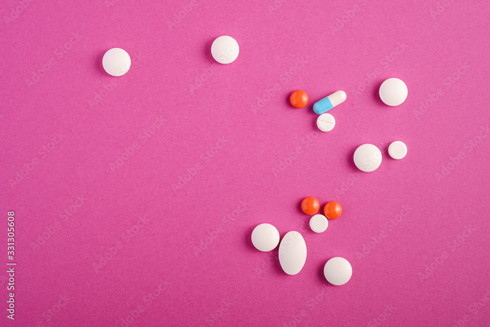 Pills and tablets on bright pink purple background, healthcare medical concept, antibiotics and cure, top view copy space