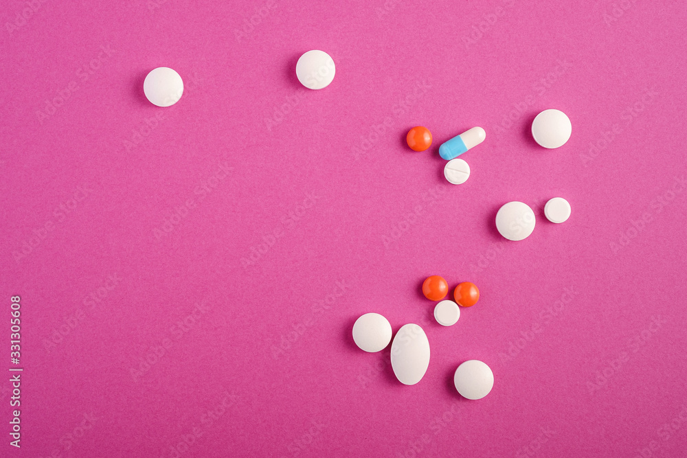 Pills and tablets on bright pink purple background, healthcare medical concept, antibiotics and cure, top view copy space Pills and tablets on bright pink purple background, healthcare medical concept, antibiotics and cure, top view copy space