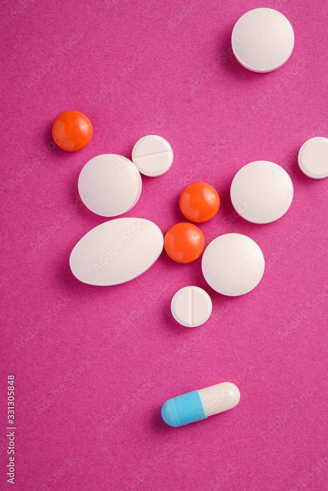 Pills and tablets on bright pink purple background, healthcare medical concept, antibiotics and cure, top view Pills and tablets on bright pink purple background, healthcare medical concept, antibiotics and cure, top view