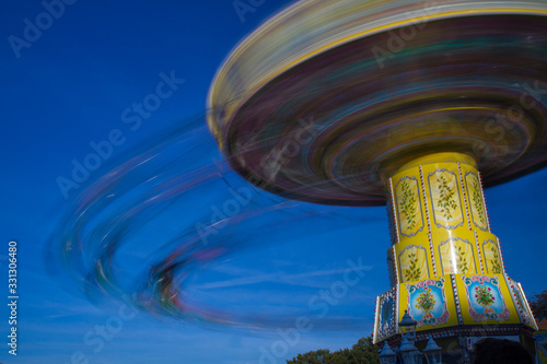 chairoplane, chain caroussel at traditional, historic fun fair in Bremen, Germany on a sunny day with blurred People and blue sky in the background photo