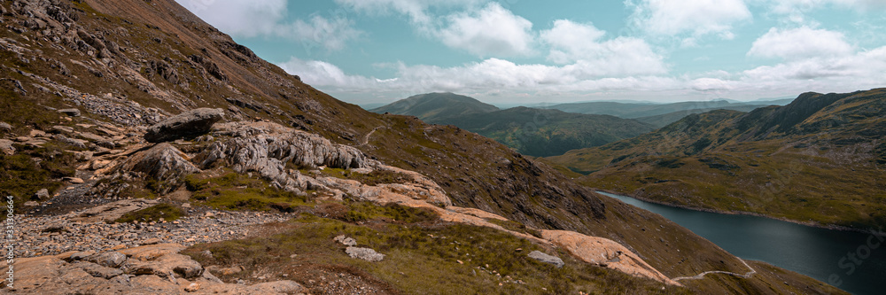 Snowdonia National Park landscape with mountains, blue sky, clouds and a lake, Gwynedd, North Wales, UK