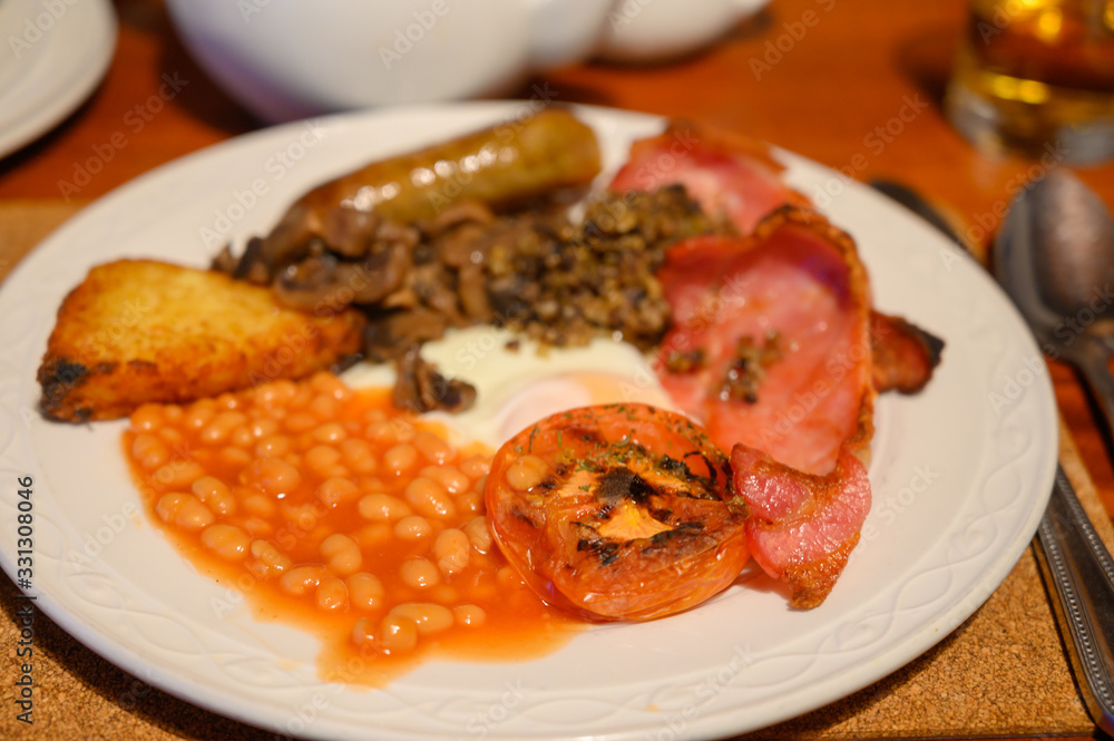 Full Scottish breakfast with bacon, fried egg, beans, tomato, roasted sausage, pudding, hash browns and haggis