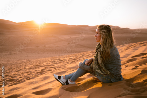 A young woman in the sahara at sunset photo