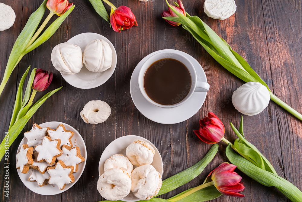 Beautiful spring tulip flowers , a cup of coffee and sweet food on rustic wooden background. Flat lay. Beautiful spring tulip flowers , a cup of coffee and sweet food on rustic wooden background. Flat lay.
