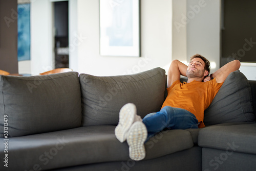 Young man relaxing on his living room sofa