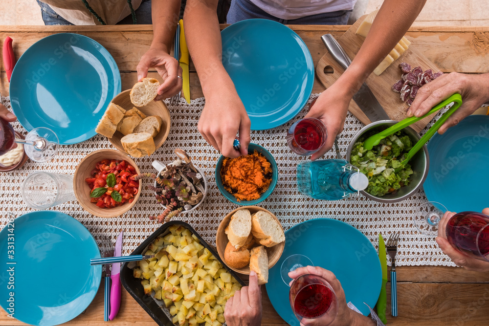 Φωτογραφία Group of people have lunch together at home enjoying time - above view of caucas