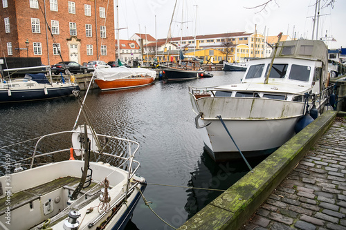 Boats on canal between Overgaden Oven Vandet and Overgaden Neden Vandet in Copenhagen, Denmark. February 2020 © vlamus
