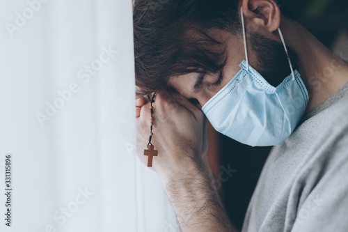 a prayer on the rosary of a mortally ill young man who has lost hope in healing and prays to the Lord for help photo