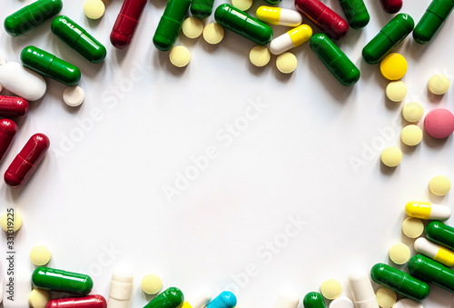 circle made of pills and capsules on white surface photo