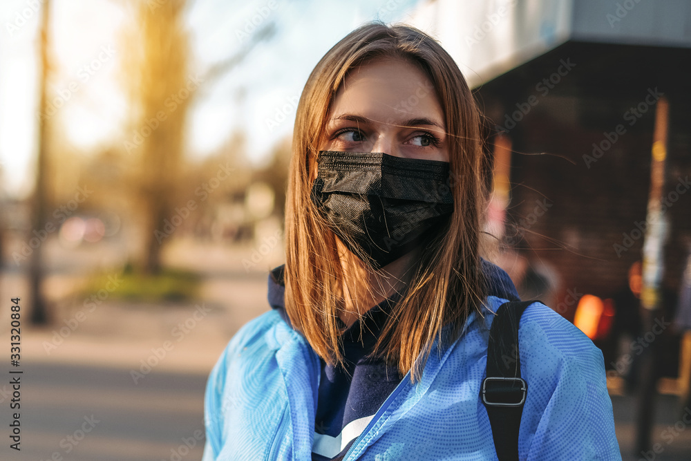 Coronavirus in Europe. the girl is standing by the road in a protective medical mask. Coronavirus in Europe. the girl is standing by the road in a protective medical mask.