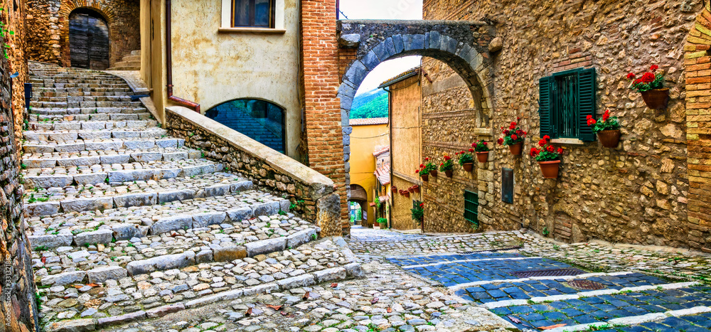 Fototapeta Urocze kwieciste uliczki starych tradycyjnych wiosek we Włoszech. Casperia, prowincja Rieti