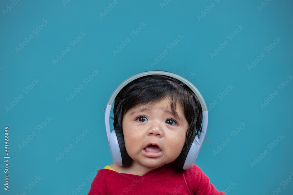 portrait of baby with headphones on blue background portrait of baby with headphones on blue background