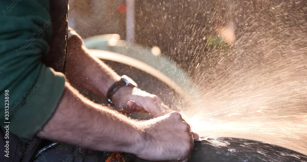 Bladesmith wet grinding a blade Bladesmith wet grinding a blade
