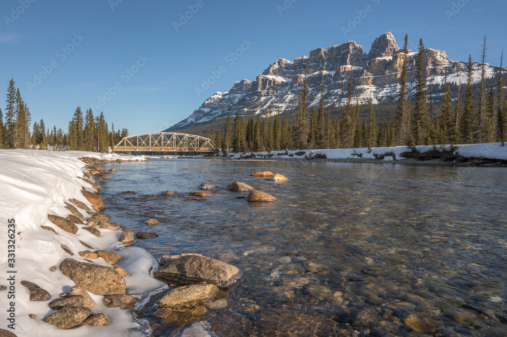 Fototapeta premium Winter view of the steel truss bridge over the Bow River at Castle Junction in Banff National Park, Alberta, Canada