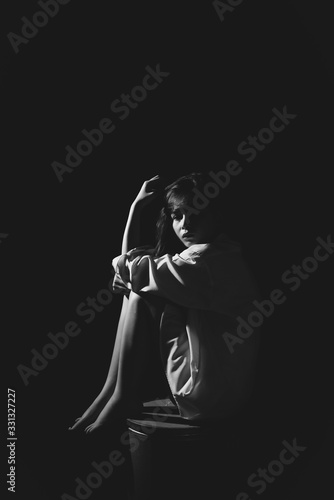 The depression woman sit on the chair on dark background, sad  asian woman silhouette in dark, monochrome image.
