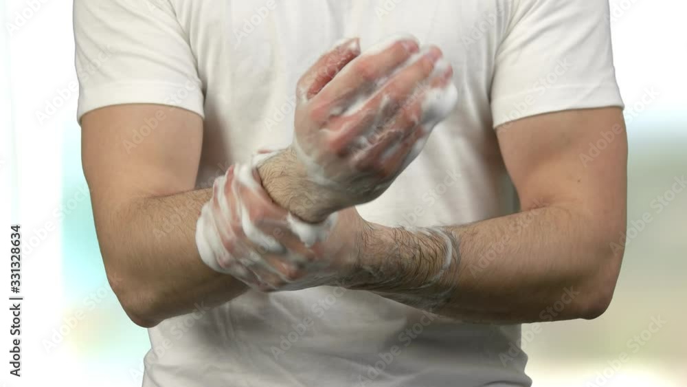 Close up caucasian man thoroughly washing his hands. Bright blurred background. Close up caucasian man thoroughly washing his hands. Bright blurred background.