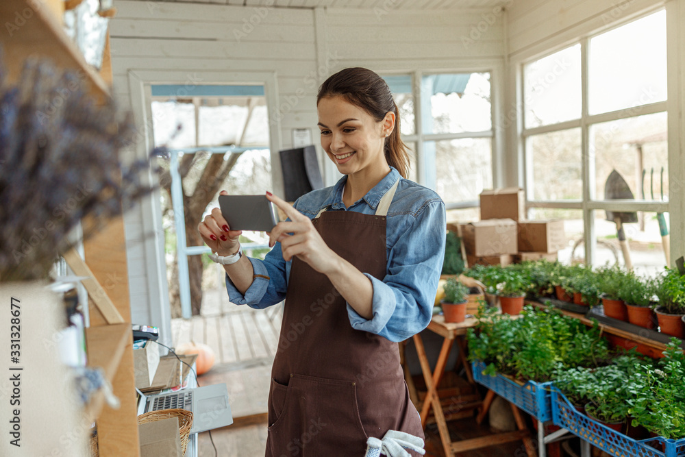 Worker photographing wooden shelves with a smartphone Worker photographing wooden shelves with a smartphone