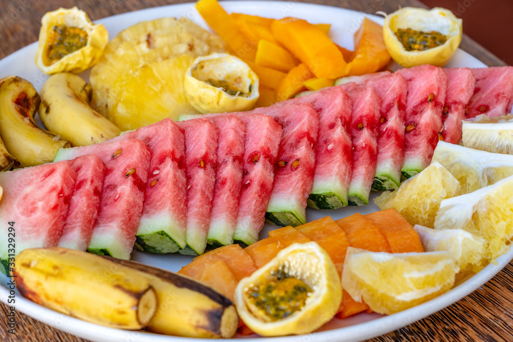 Tropical fruits on a breakfast plate, close up, top view Tropical fruits on a breakfast plate, close up, top view