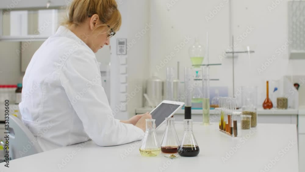 Close up of chemist working with hemp CBD oil and tablet in laboratory Close up of chemist working with hemp CBD oil and tablet in laboratory