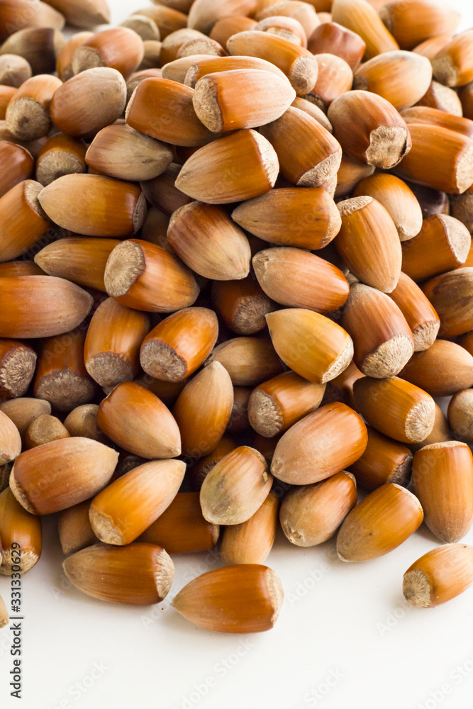Ripe,new crop hazelnuts heap on white background with copy space,vertical image Ripe,new crop hazelnuts heap on white background with copy space,vertical image