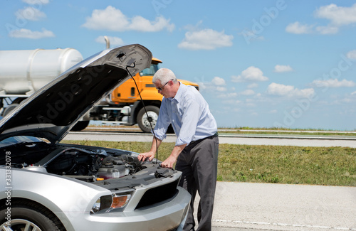 man with broken down car on highway