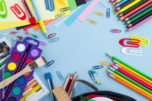 Colorful school supplies on the pastel blue color ground,made a frame with blank space for any text message.