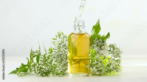 Essence of flowers on table in beautiful glass jar photo