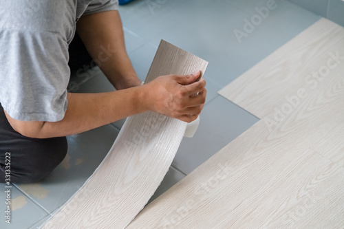 Schilderij op canvas A person installing new vinyl tile floor, a DIY home project.
