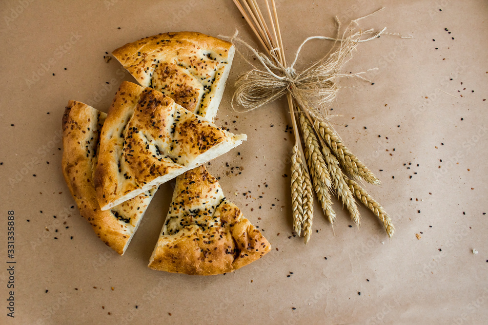 Puffy and circular Ramadan bread (pide) sliced on the kraft paper ...