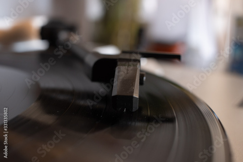 Close up of turntable needle on a vinyl record. Turntable playing vinyl. Needle on rotating black vinyl.