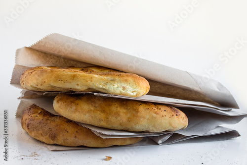 Fresh Ramadan Breads "Pide"stacked in own craft packaging on the white surface with copy space.